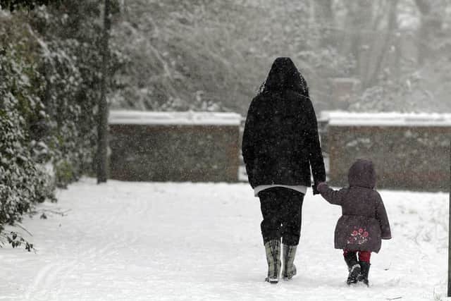 A mother holding her daughter's hand in the snow (Photo: Shutterstock)