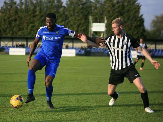 Corby Town captain Gary Mulligan challenges Dunstable Town's Arel Amu during the 3-3 draw at the weekend