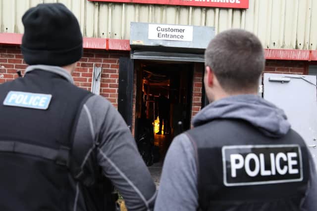 Officers look into the entrance to the cannabis factory.