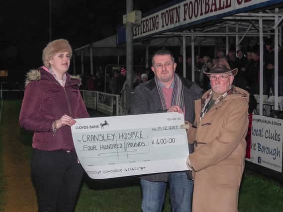 Cransley Hospice volunteer Yaiza Conde receives a cheque from Dave Rose of the Kettering Civic Society along with artist Len Litchfield. Picture by Barry Medlock