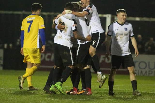 Phil Trainer is mobbed by his Corby Town team-mates after scoring their third goal in the 3-1 success over Spalding United. Pictures by Alison Bagley