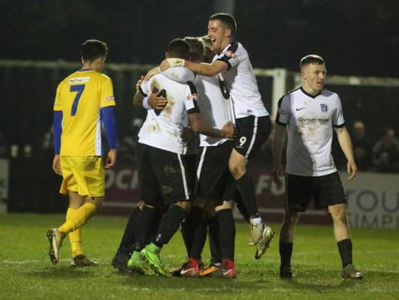 Phil Trainer is mobbed by his Corby Town team-mates after scoring their third goal in the 3-1 success over Spalding United. Pictures by Alison Bagley
