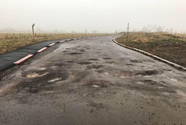 Potholes on the access road to Hayfield Cross School. NNL-181101-125641005