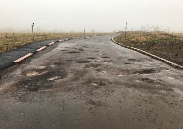 Potholes on the access road to Hayfield Cross School. NNL-181101-125641005