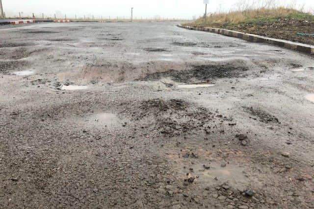 Potholes on the access road to Hayfield Cross School. NNL-181101-125651005