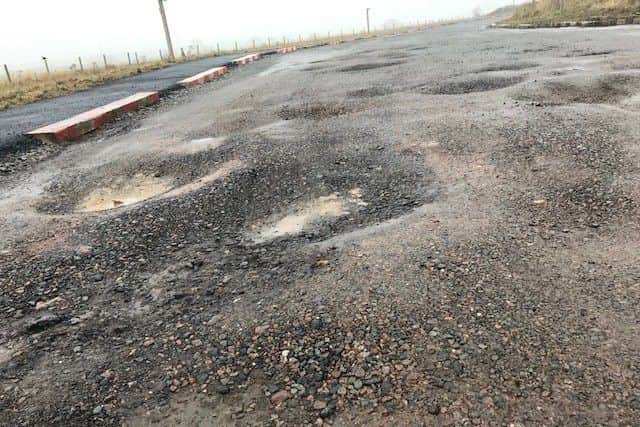 Potholes on the access road to Hayfield Cross School. NNL-181101-125631005