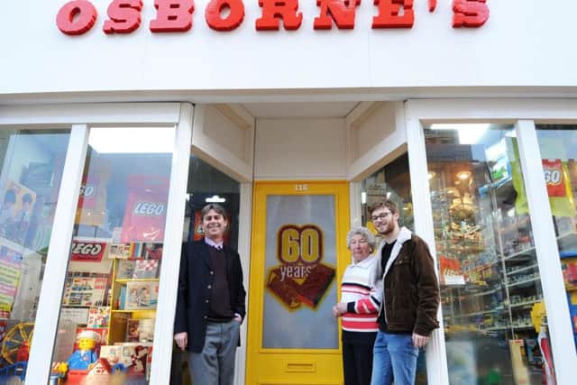 Will Osborne with his mother Pamela and son James outside Osbornes toy shop in Rushden, which has had its faade re-created in LEGO to celebrate the 60th Anniversary of the famous brick