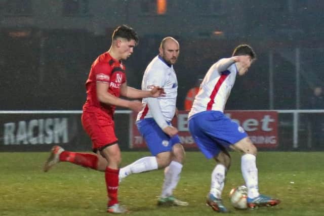 Sam Brown and Liam Dolman combine to stop Kettering striker Mathew Stevens