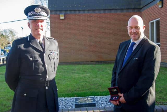 Chief Constable Simon Edens with Ian Churms by the memorial for Police Dog Bryn