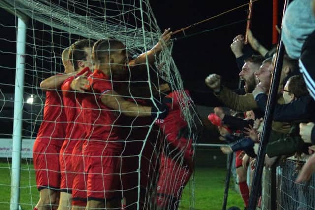 The Kettering Town players and fans celebrate Aaron O'Connor's late winner as they came from 3-2 down to beat 10-man Dorchester Town 4-3 at Latimer Park. Pictures by Peter Short