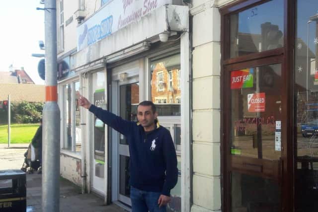 Kamal Paul outside his shop in Montagu Street, pointing to where the missing sign should be. NNL-180904-130902005