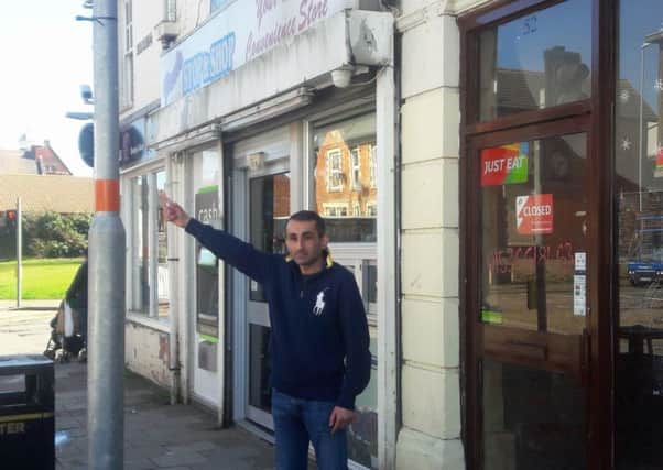 Kamal Paul outside his shop in Montagu Street, pointing to where the missing sign should be. NNL-180904-130902005
