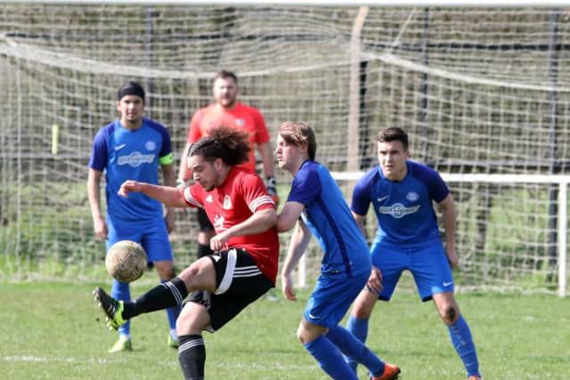 Irchester United and Lutterworth Athletic battle for possession at Alfred Street