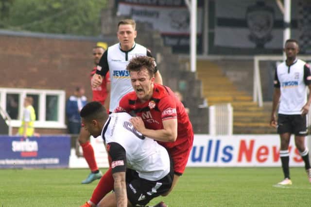 Ben Milnes is on the end of a heavy challenge during Kettering's loss at Hereford