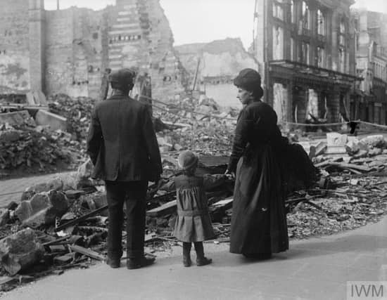 A refugee family returning to Amiens, looking at the ruins of a house, September 17, 1918.© IWM (Q 11341)