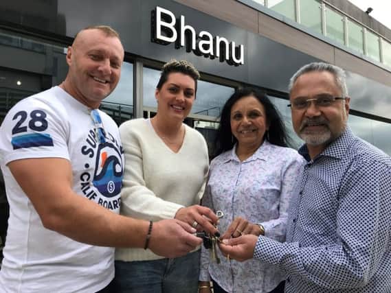 Roberto and Alina Steffanescu (left) receiving the keys to the
Bhanu store from Jo and Henry NNL-180920-160843005