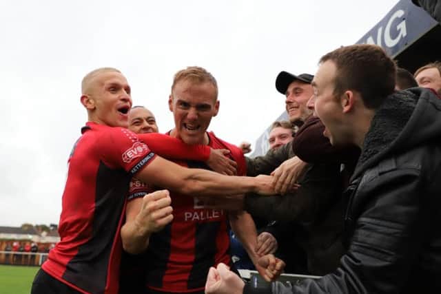 Brett Solkhon celebrates with his team-mates and the Kettering Town fans after completing a hat-trick of penalties during the 4-0 FA Cup success over Hednesford Town. Pictures by Peter Short