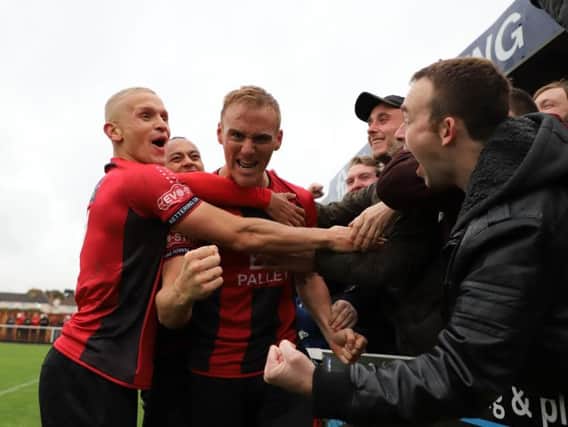 Brett Solkhon celebrates with his team-mates and the Kettering Town fans after completing a hat-trick of penalties during the 4-0 FA Cup success over Hednesford Town. Pictures by Peter Short