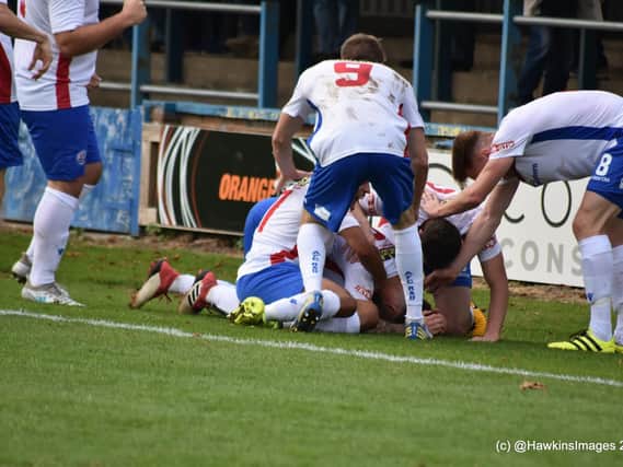 Declan Rogers is buried under of a pile of his AFC Rushden & Diamonds team-mates after he put them in front in the 1-1 draw at King's Lynn Town. Picture courtesy of HawkinsImages