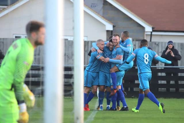 Dan Holman is mobbed by his team-mates after he scored the only goal of the game