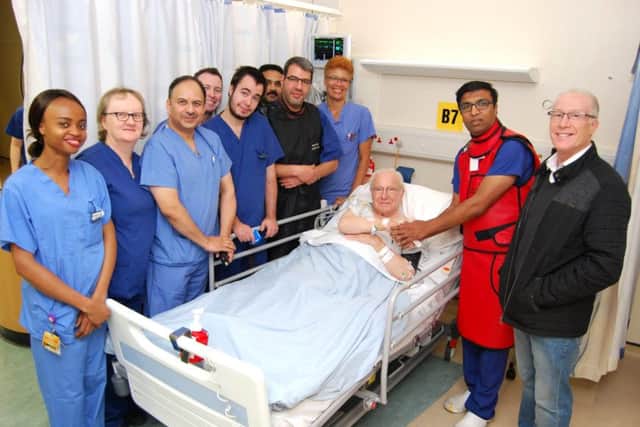 The first patient to have the procedure, Jack Hadley, 85, shakes hands with Consultant Interventional Cardiologist, Dr Prashanth Raju. He is pictured with his son, Laurence Hadley, and members of KGHs cardiology team. NNL-181122-111504005