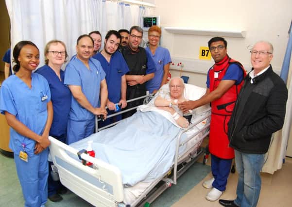 The first patient to have the procedure, Jack Hadley, 85, shakes hands with Consultant Interventional Cardiologist, Dr Prashanth Raju. He is pictured with his son, Laurence Hadley, and members of KGHs cardiology team. NNL-181122-111504005