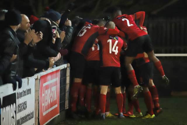 Dan Holman is mobbed by his Kettering Town team-mates after he scored his second goal to put them 4-3 up, only for them to concede late on in their 4-4 draw with Redditch United at Latimer Park. Picture by Peter Short