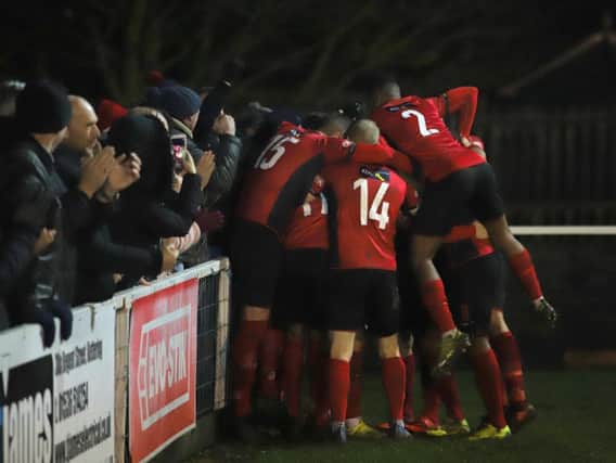 Dan Holman is mobbed by his Kettering Town team-mates after he scored his second goal to put them 4-3 up, only for them to concede late on in their 4-4 draw with Redditch United at Latimer Park. Picture by Peter Short