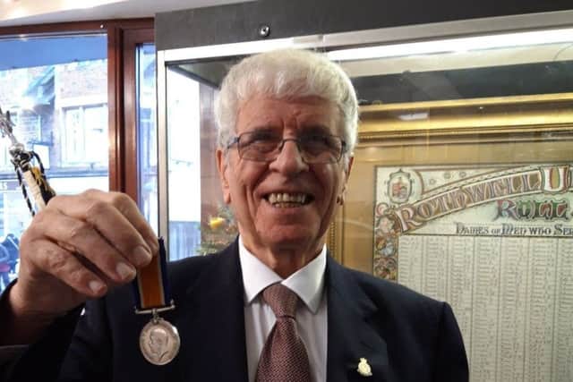 A delighted Brian with his grandfather's medal.