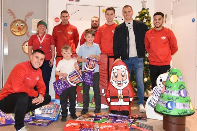 Kettering Town players and staff visited Kettering General Hospital's Skylark Ward to bring some festive cheer to the children over the Christmas period. They were giving out chocolates and gifts donated by supporters. Picture by Paul Cooke/KTFC Media