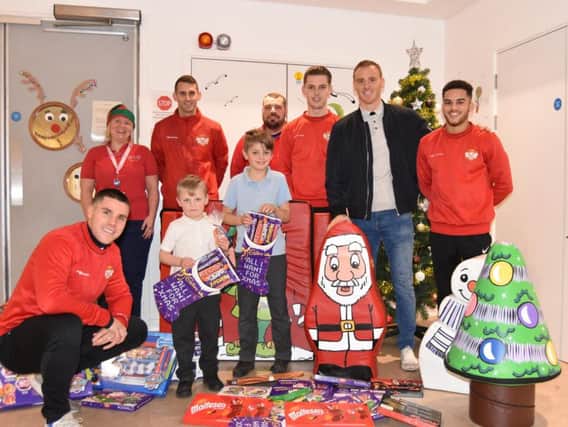 Kettering Town players and staff visited Kettering General Hospital's Skylark Ward to bring some festive cheer to the children over the Christmas period. They were giving out chocolates and gifts donated by supporters. Picture by Paul Cooke/KTFC Media