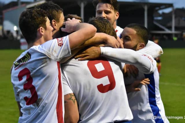 Tom Lorraine is mobbed by his team-mates after he opened the scoring