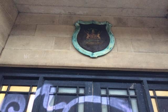 The coat of arms above the doors has rusted badly. NNL-181228-174713005