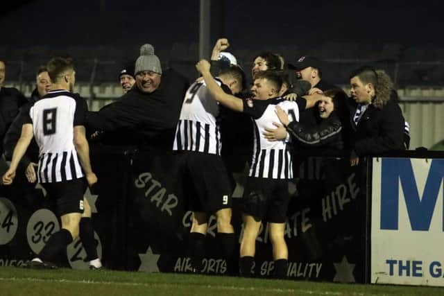 Elliot Sandy celebrates with the Corby Town fans and his team-mates after he completed the scoring in the 4-1 success over Cambridge City. Pictures by Alison Bagley
