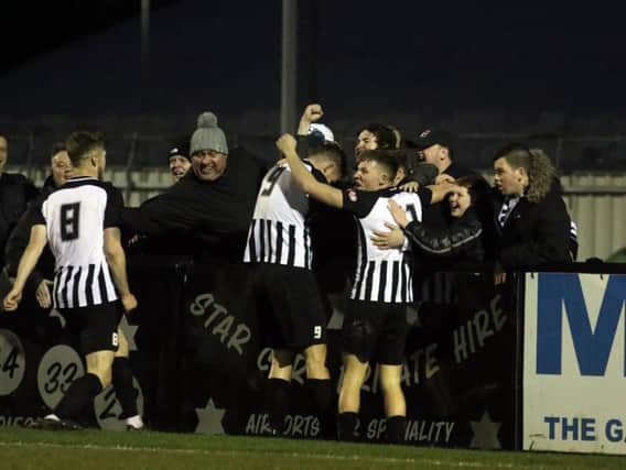 Elliot Sandy celebrates with the Corby Town fans and his team-mates after he completed the scoring in the 4-1 success over Cambridge City. Pictures by Alison Bagley