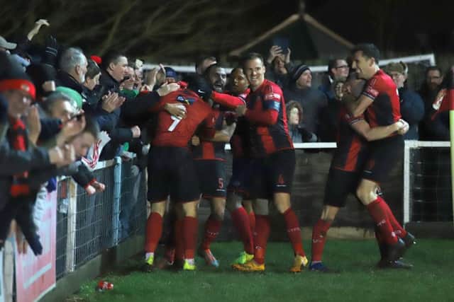 Rhys Hoenes is mobbed by his Kettering Town team-mates after he scored the late winner on New Year's Day. The Poppies are on home soil again this weekend when they host Tamworth. Picture by Peter Short