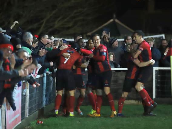 Rhys Hoenes is mobbed by his Kettering Town team-mates after he scored the late winner on New Year's Day. The Poppies are on home soil again this weekend when they host Tamworth. Picture by Peter Short