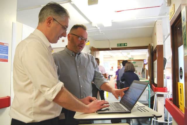 Pharmacist Anthony Bartlett, and Chief of Family Health Division and Chief Pharmacist, Duane McLean, with a computer pedestal of the type to be used on the wards once the electronic prescribing system is fully operational