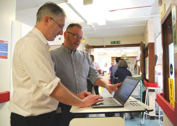Pharmacist Anthony Bartlett, and Chief of Family Health Division and Chief Pharmacist, Duane McLean, with a computer pedestal of the type to be used on the wards once the electronic prescribing system is fully operational