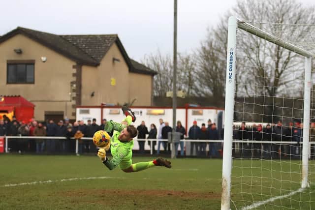 Royston goalkeeper Joe Welch was forced into a number of saves including this one from a Michael Richens header