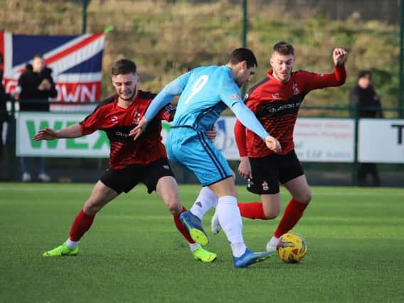 Dan Holman takes on two Redditch United defenders during Kettering Town's 4-1 victory. Picture by Peter Short
