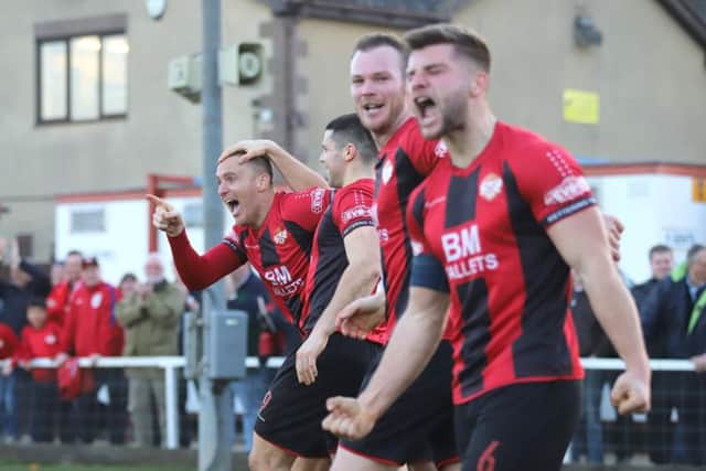 The Kettering Town players show their delight after Brett Solkhon's stoppage-time goal secured a 2-1 success over Rushall Olympic at Latimer Park. Pictures by Peter Short