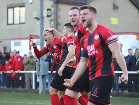 The Kettering Town players show their delight after Brett Solkhon's stoppage-time goal secured a 2-1 success over Rushall Olympic at Latimer Park. Pictures by Peter Short