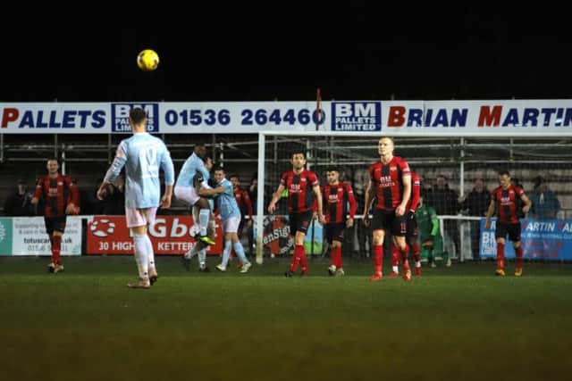 The Kettering Town players look dejected while Coalville Town celebrate their late winner at Latimer Park. Pictures by Peter Short