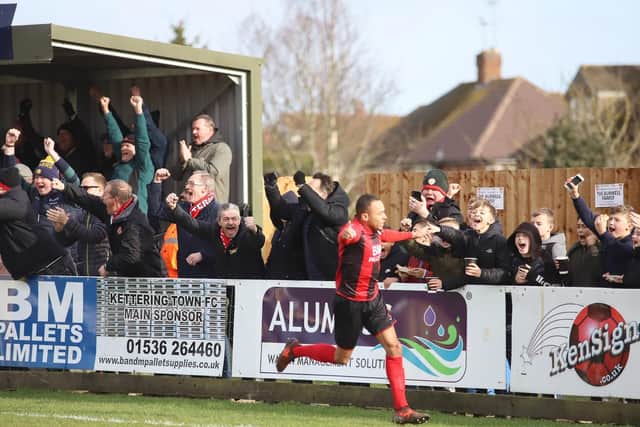 Rhys Hoenes heads off to celebrate, much to the delight of the Kettering Town fans, after he opened the scoring in the 3-0 win over Banbury United. Pictures by Peter Short