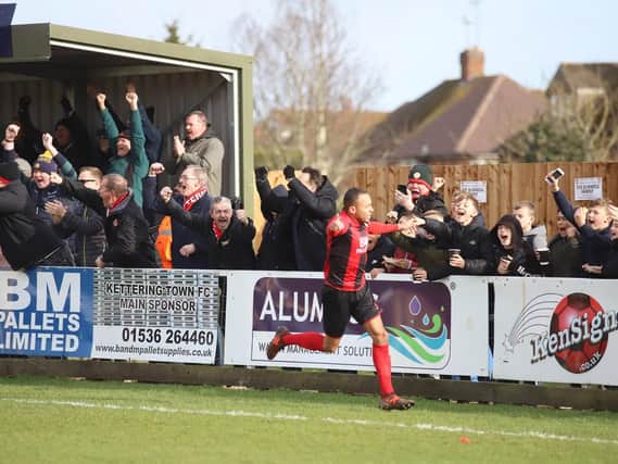 Rhys Hoenes heads off to celebrate, much to the delight of the Kettering Town fans, after he opened the scoring in the 3-0 win over Banbury United. Pictures by Peter Short