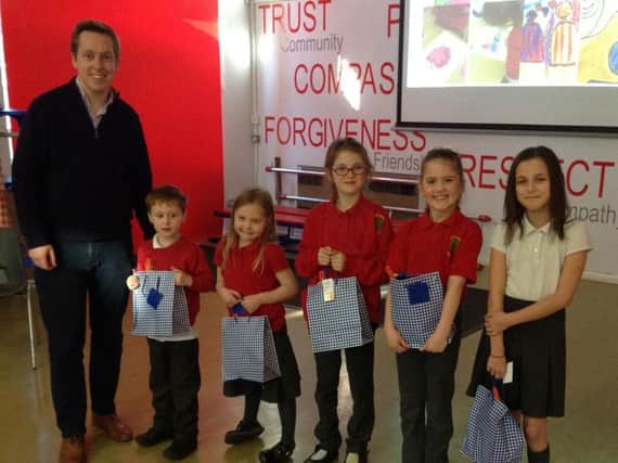 Corby MP Tom Pursglove presents prizes and certificates to Cottingham C of E Primary School children