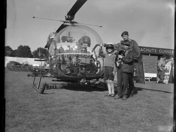 Two young pilots (and a puppy ) pose next to an army helicopter at the Northampton Show, August 5, 1966