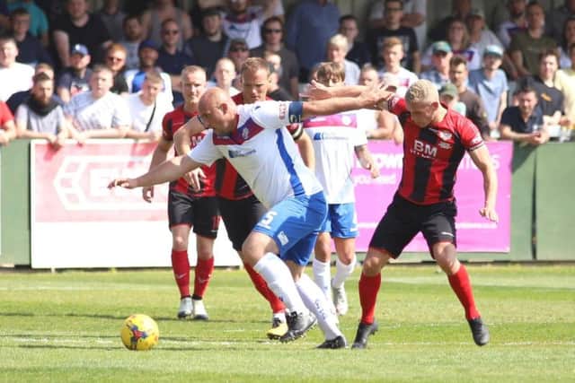 AFC Rushden & Diamonds captain Liam Dolman holds off the challenge of Lindon Meikle during Monday's clash with Kettering Town. Picture by Peter Short