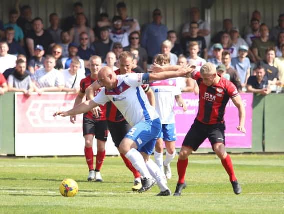 AFC Rushden & Diamonds captain Liam Dolman holds off the challenge of Lindon Meikle during Monday's clash with Kettering Town. Picture by Peter Short
